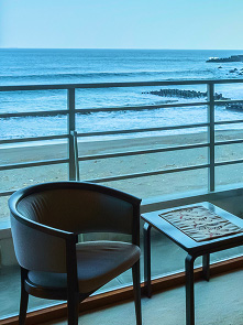海が見えるバルコニーの一角。肘掛け椅子と小さなテーブルが置かれている。