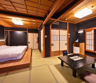 夕暮れ時の景色を望む二つの窓。左側の窓は木製の縦格子とガラス戸で、その奥には露天風呂のような場所と青い海が見える。右側の窓は障子とガラス戸の組み合わせで、一部の障子が上げられており、青い海と水平線が広がっている。