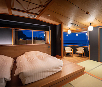 海辺に面した、開放的な雰囲気の露天風呂。手前には、丸い石造りの湯船があり、透明感のある湯が波紋を描いている。